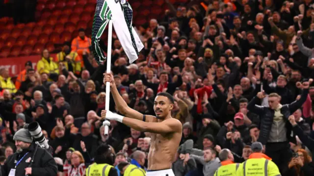 Sunderland goalscorer Wison Isidor raises a corner flag into the air with his shirt attached