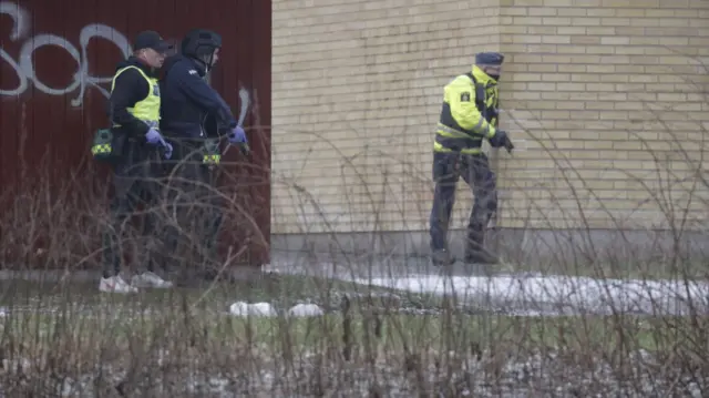 Police with guns at the school earlier