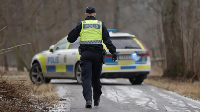 A police officer walks as a major police operation is under way at Risbergska School