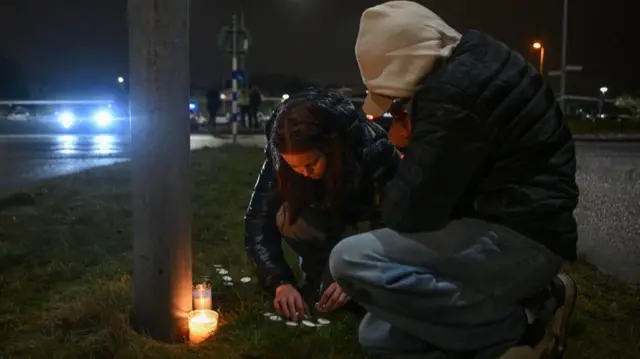 People light candles at a makeshift vigil in Orebro, Sweden, on February 4, 2025 after a shooting at the adult education center Campus Risbergska school, where "around 10 people have been killed"