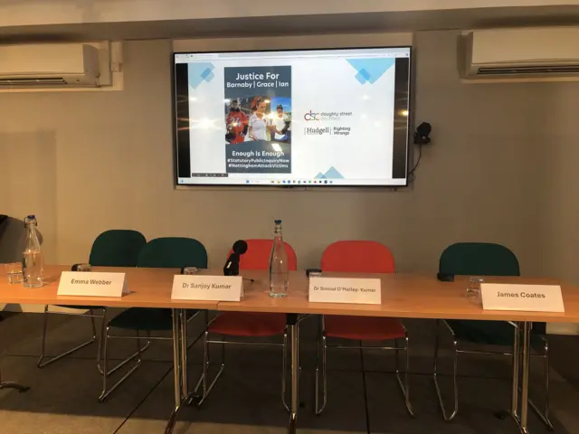 An empty row of chairs and a projector in place ahead of a press conference