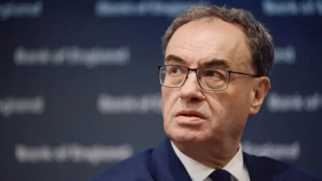 BoE governor Andrew Bailey close up as he looks to his right, head slightly twisted sideways. He's wearing a dark blue jacket, white shirt and blue tie