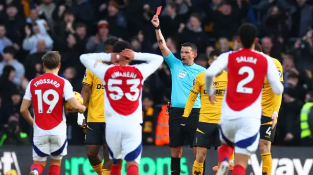 Michael Oliver shows Myles Lewis-Skelly a red card