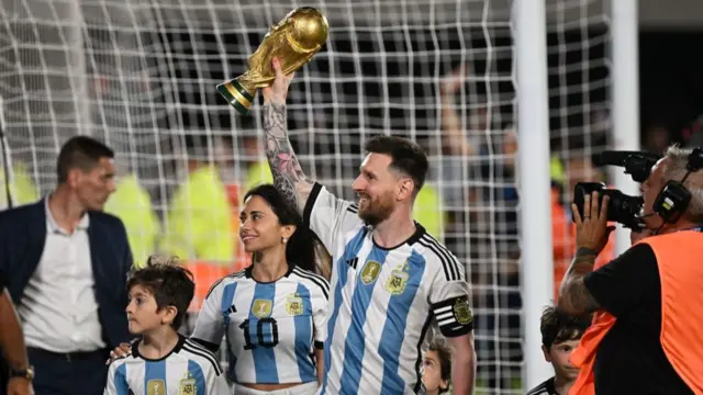 Lionel Messi celebrates with World Cup trophy