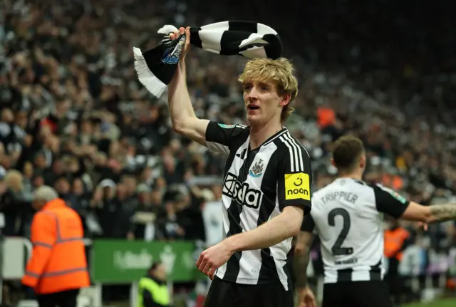 Gordon holds a Newcastle scarf over his head