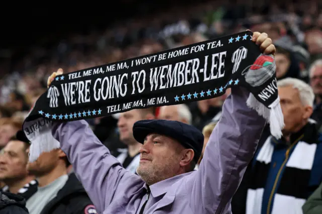 Fan holds up a 'We're going to Wembley' scarf