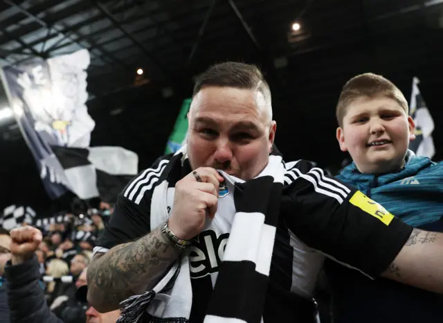 Newcastle fan kisses the badge on his shirt