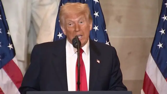 Trump speaking into a microphone