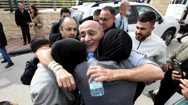 A Palestinian former detainee is greeted by family and friends as he arrives after being released from prison