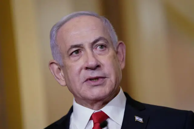 Benjamin Netanyahu in front of a dark yellow background.