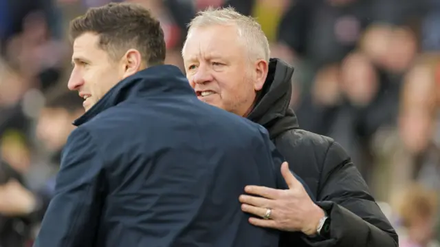 Chris Wilder and John Mousinho embrace just before kick-off