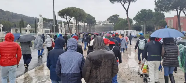 Fans on the street in the Rome rain