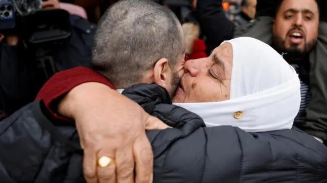 A freed Palestinian prisoner is being hugged by a woman after being released from an Israeli jail