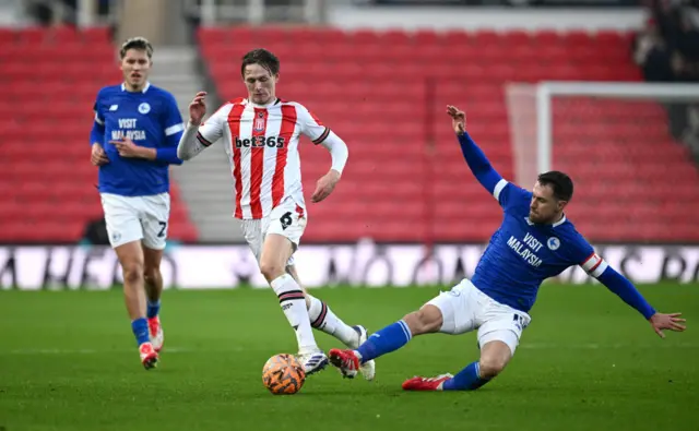 Wouter Burger of Stoke City is challenged by Aaron Ramsey of Cardiff City