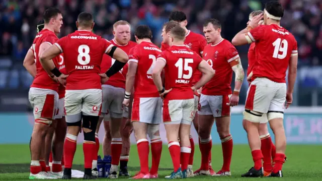 Welsh players huddle after defeat in Rome