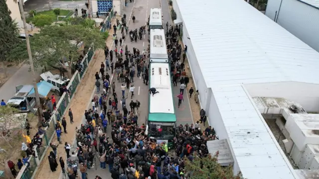 A crowd surrounds busses transporting Palestian prisoners from Israeli prisons