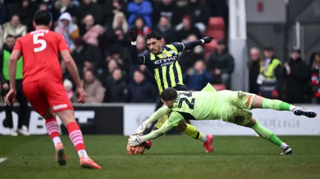 Omar Marmoush of Manchester City is challenged by Josh Keeley of Leyton Orient