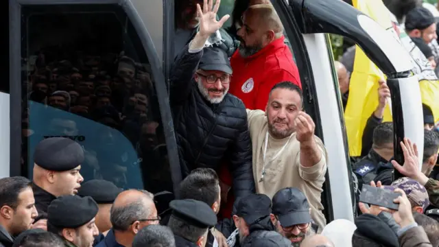 A freed Palestinian prisoner waves after being released from an Israeli jail