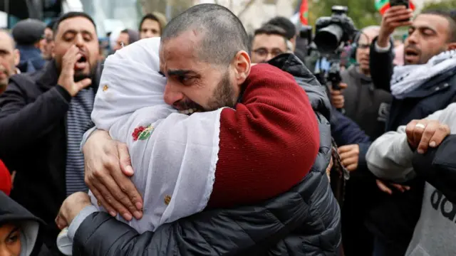 A freed Palestinian prisoner is hugging a woman after being released from an Israeli jail as part of a hostages-prisoners swap