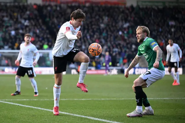 Federico Chiesa of Liverpool controls the ball under pressure from Lewis Gibson of Plymouth Argyle