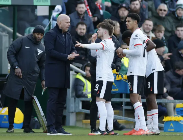 Liverpool manager Arne Slot gives instructions to Harvey Elliott during a break in play