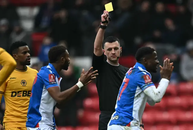 Referee Lewis Smith shows a yellow card to Blackburn Rovers' Welsh Sierra Leonean Augustus Kargbo for diving