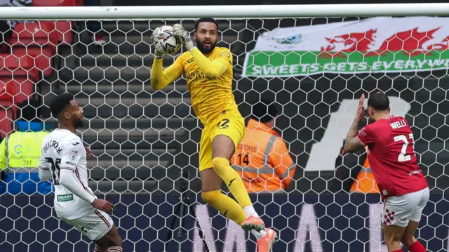 Swansea City goalkeeper Lawrence Vigouroux claims the ball