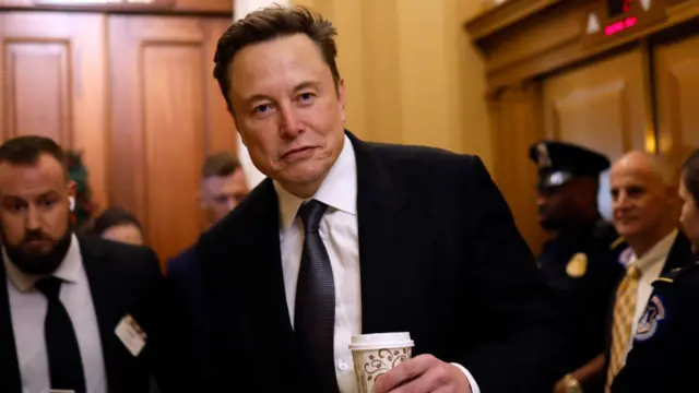 Elon Musk holding a coffee cup