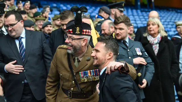 Rangers chairman Fraser Thornton (L) interim head coach Barry Ferguson (centre) and CEO Patrick Stewart (R) with members of the armed forces as part of Armed Forces Day before a William Hill Premiership match between Rangers and Motherwell at Ibrox Stadium