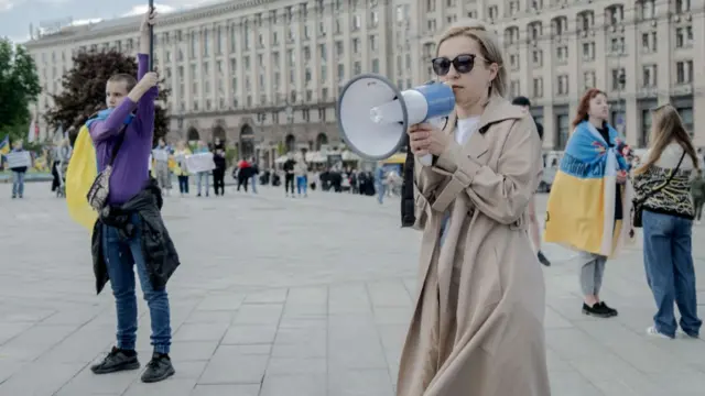 Ukrainian opposition MP Inna Sovsun holding a megaphone in the street