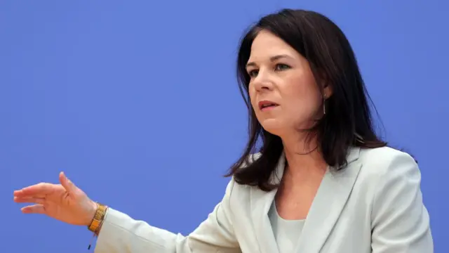 German foreign minister Annalena Baerbock wears a blue blazer and top and gestures with her hand.