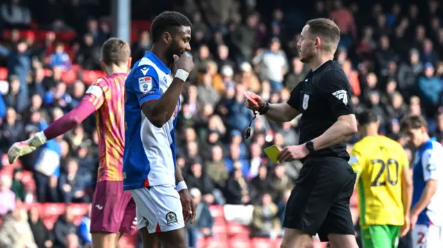 Emmanuel Dennis (left) is shown a red card