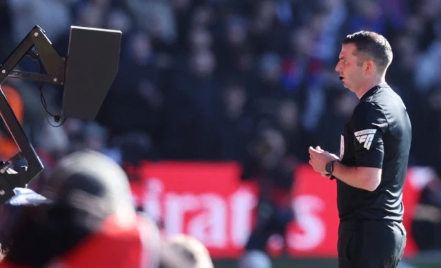 Referee Michael Oliver looks at the VAR monitor