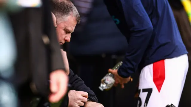 Mark Robins checks his watch