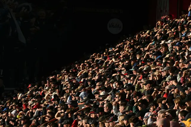 Supporters shade their eyes from the sun