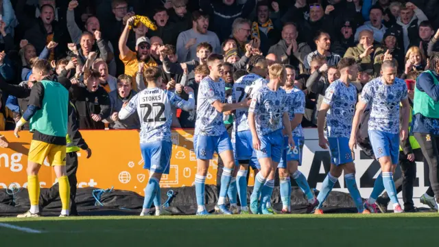 Cambridge players celebrate their opening goal at Crawley