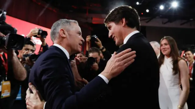 Former Bank of Canada and Bank of England governor Mark Carney and Justin Trudeau embrace