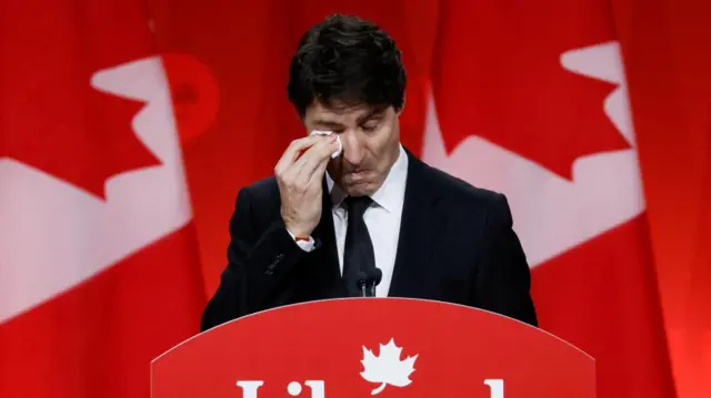 Justin Trudeau dabs his right eye with tissue paper as he wipes away tears in his farewell address.