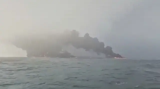 Image shows smoke coming out a ship in the sea