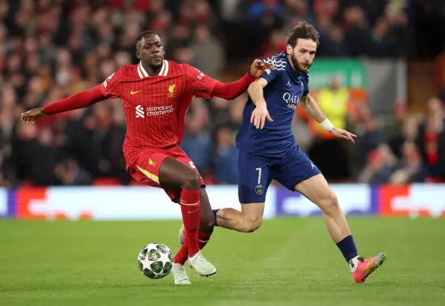 Ibrahima Konate (L) of Liverpool in action against Khvicha Kvaratskhelia of PSG.