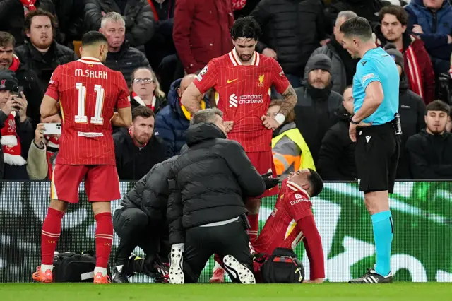 Liverpool's Trent Alexander-Arnold (centre right) recieves treatment from medical staff.