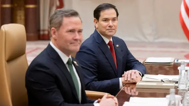 U.S. Secretary of State Marco Rubio and U.S. National Security Advisor Mike Waltz (left) wear suits and sit at a table.