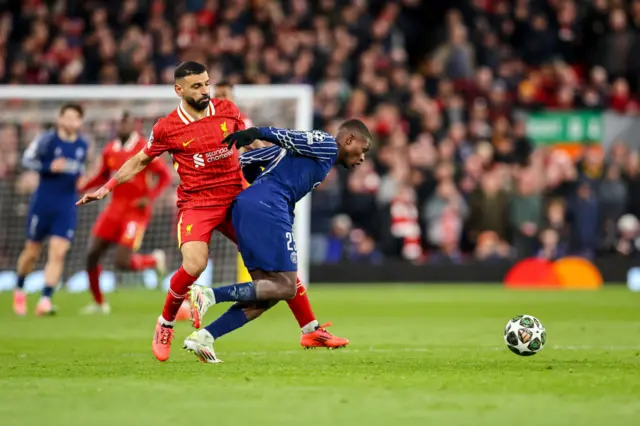 Mo Salah of Liverpool FC and Nuno Mendes of PSG battle for the ball