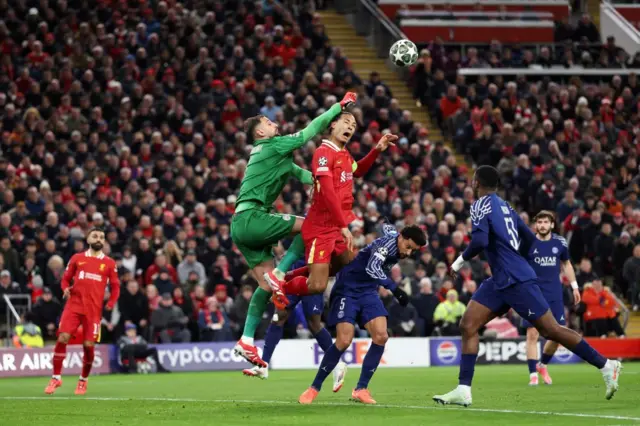 Paris Saint-Germain's Italian goalkeeper #01 Gianluigi Donnarumma (C-L) stops the ball as he fights for it with Liverpool's Dutch defender #04 Virgil van Dijk.