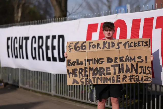 Manchester United supporter with ticket price banner