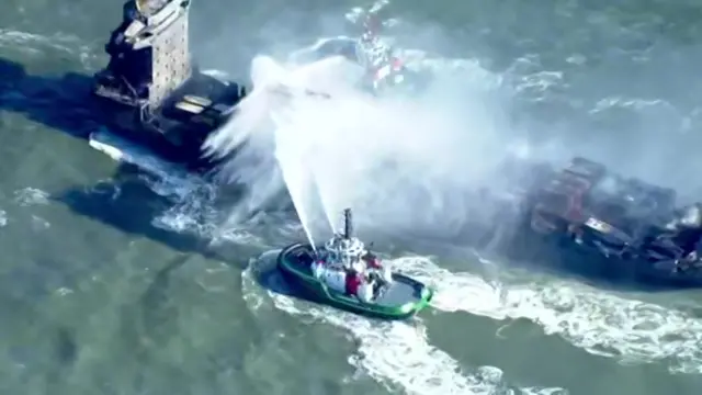 Tanker being sprayed by water from a smaller vessel