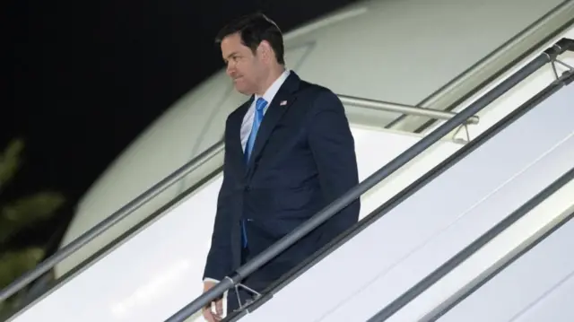 Marco Rubio descends a plane