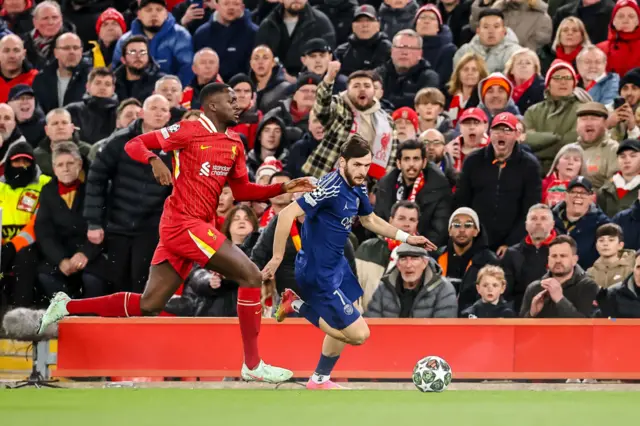 Ibrahima Konate of Liverpool FC and Khvicha Kvaratskhelia of PSG battle for the ball.