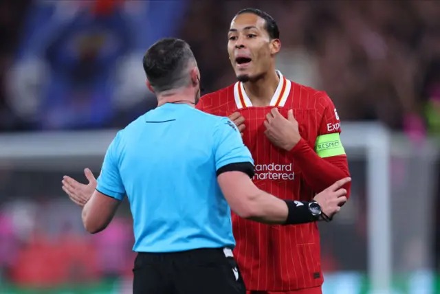 Referee Istvan Kovacs speaks to Virgil van Dijk of Liverpool.