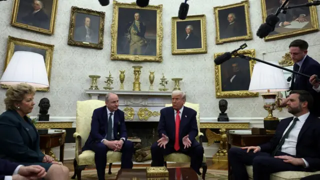 Trump answers questions from the White House press pool in the Oval Office alongside the Irish PM and Vice President JD Vance. All are seated and wearing suits.